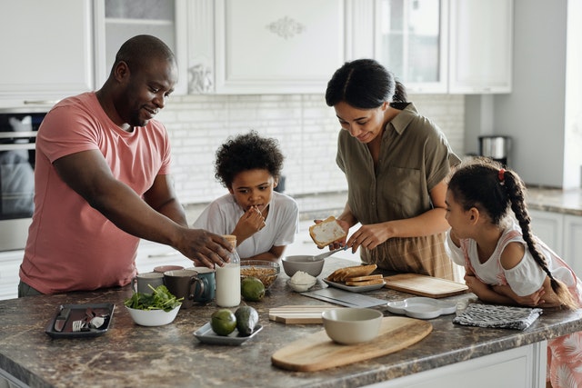Une famille faisant le petit déjeuner dans la cuisine