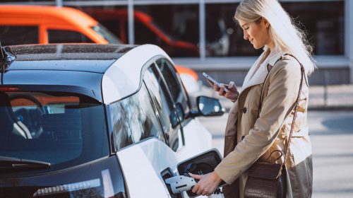 une femme rechargeant sa voiture électrique