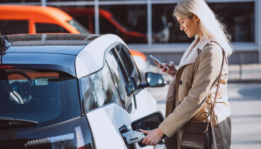 une femme rechargeant sa voiture électrique